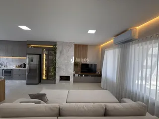 Sala de estar moderna com sofá e lareira em um apartamento no Brasil.