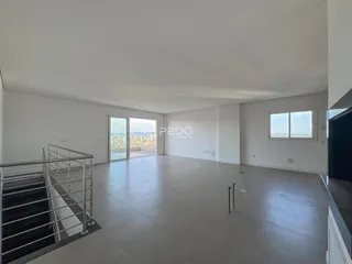 Sala ampla com porta de vidro abrindo para a vista externa.