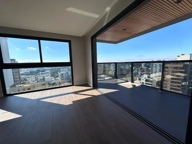 Vista panorâmica da cidade vista através de grandes janelas de uma sala.