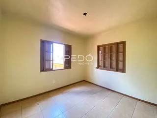 Imagem de uma sala com piso de cerâmica e armário em madeira.
