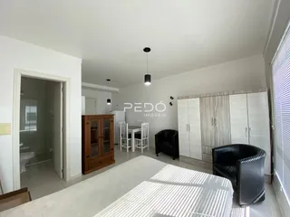 Interior de uma sala com armários e móveis escuros.