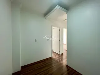 Hall de entrada com piso de madeira e paredes claras.