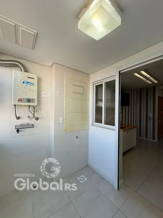 Vista interna de um corredor com paredes brancas e piso de cerâmica.