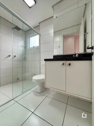 Foto de um banheiro com box de vidro e piso cerâmico.