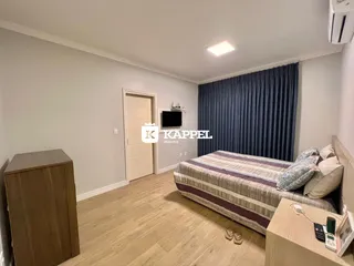 Quarto com cama e cortinas azuis em um imóvel.