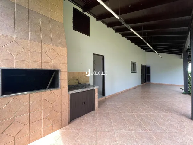 Hall com piso de cerâmica e estrutura de teto de madeira.