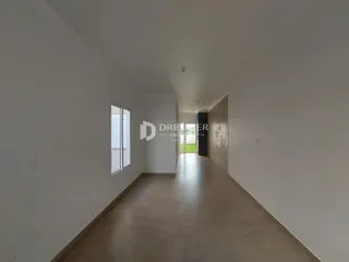 Corredor interno de uma residência com paredes brancas e piso claro.