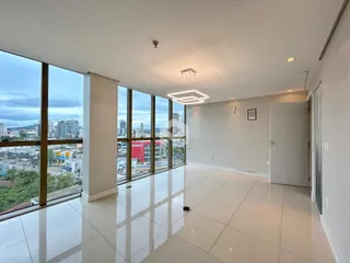 Sala de estar com grandes janelas que oferecem uma vista da cidade.