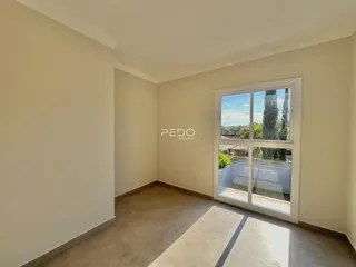 Ambiente interno de uma sala com piso de cerâmica e janela de vidro.