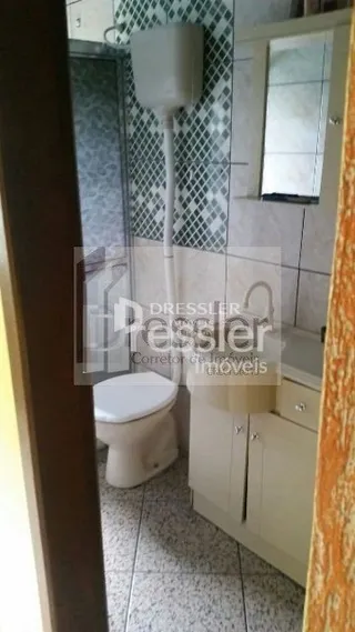 Foto de um banheiro interno com revestimento de azulejos brancos.