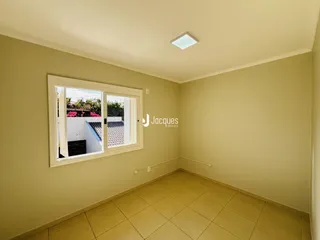 Ambiente interno de uma sala com piso de cerâmica e janela.