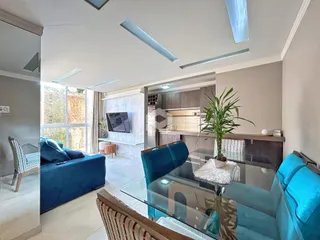 Sala de estar e jantar com vista para o exterior em um imóvel em Lajeado.