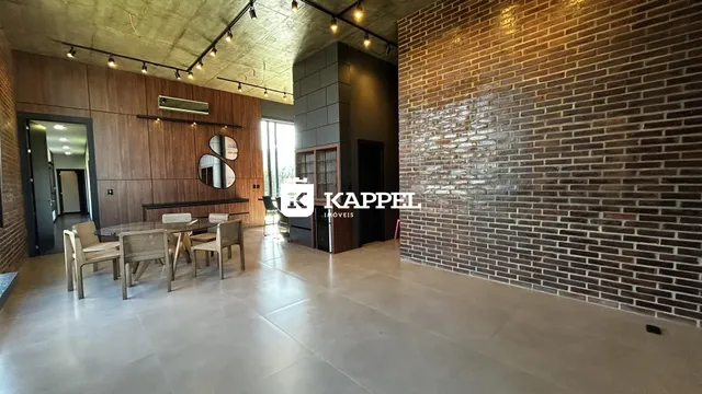 Uma sala de jantar com mesa e cadeiras em um ambiente com piso de porcelanato claro.