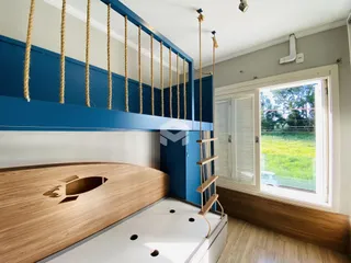 Quarto com cabeceira de madeira e detalhes em azul na decoração.