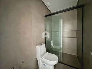 Banheiro com box de vidro e vaso sanitário.