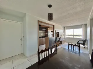 Interior de uma sala de estar com acesso à cozinha.