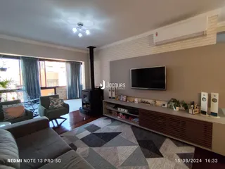 Sala de estar com lareira e televisão em um imóvel no Lajeado.