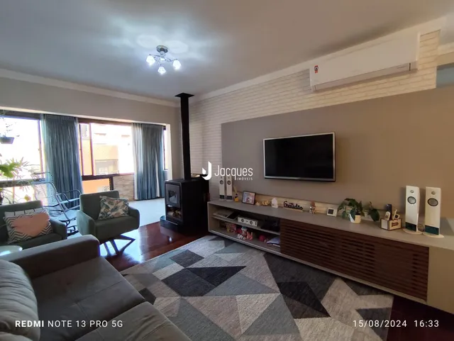 Sala de estar com lareira e televisão em um imóvel no Lajeado.