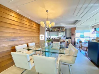 Sala de jantar com mesa de vidro e cadeiras brancas em um ambiente bem iluminado.