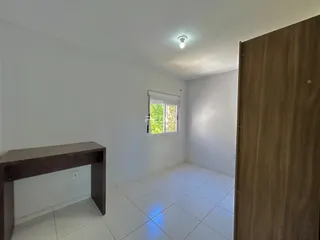 Uma sala com paredes brancas e piso de cerâmica clara.