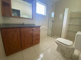 Foto de um banheiro com piso de cerâmica e louças brancas.