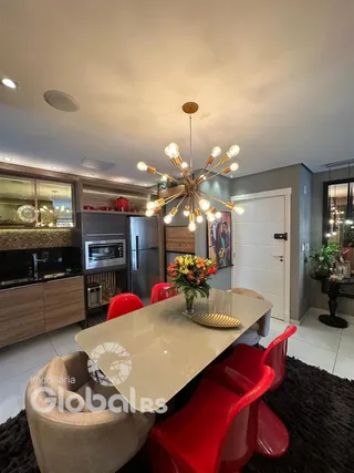 Sala de jantar com mesa e cadeiras vermelhas em um ambiente moderno.