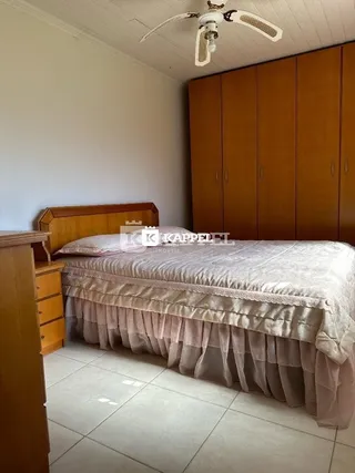 Quarto com cama e armários de madeira na sala.