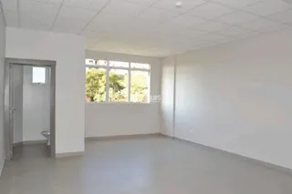 Ambiente interno de uma sala com paredes brancas e teto de gesso.