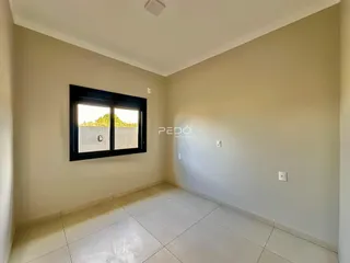 Ambiente interno de uma sala com piso de cerâmica e janela.