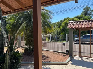 A fachada da propriedade em Lajeado, Brasil, mostra o muro e a vegetação do quintal.