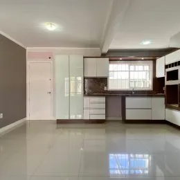 Foto de uma sala de estar com armários brancos e piso claro.