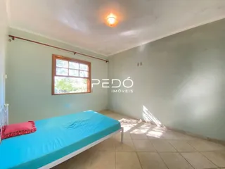 Quarto com cama e janela em sala de estar.
