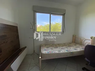 Quarto com cama e cabeceira de madeira.