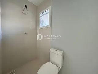 Um banheiro com piso de cerâmica e paredes brancas.