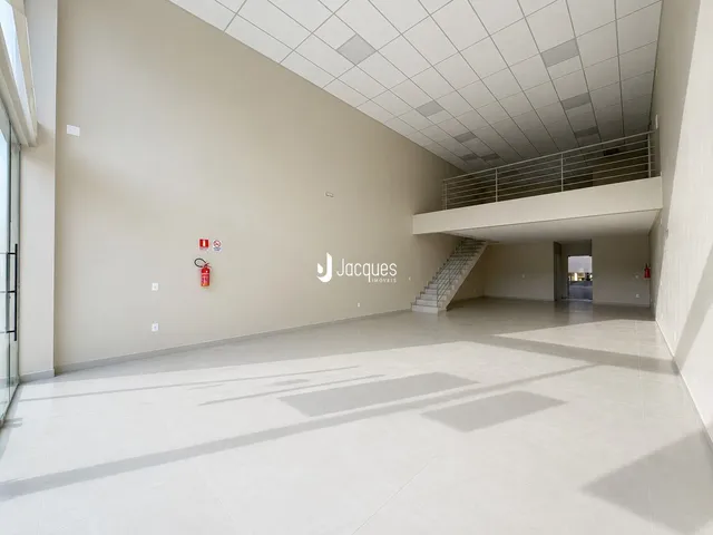 Espaço interno amplo com teto alto e escadaria.