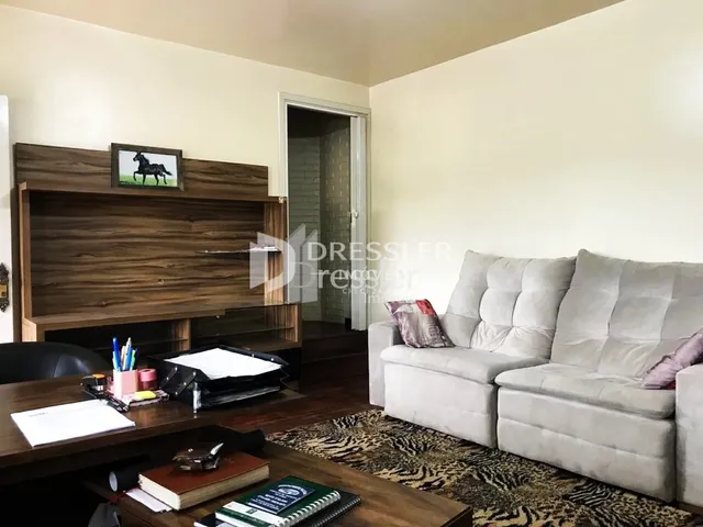 Sala de estar com sofá e estante de madeira.