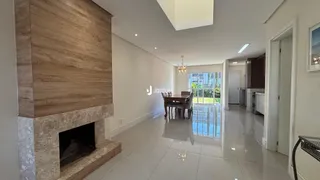 Uma sala de estar ampla com lareira e piso claro.