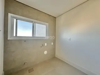 Vista interna de um cômodo com parede lisa e janela.