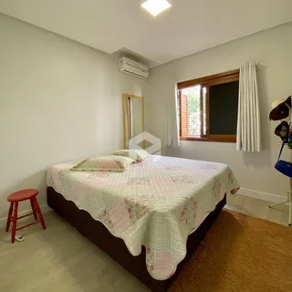 Quarto com cama e janela de madeira.