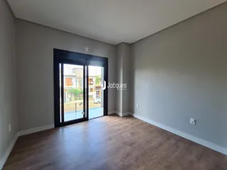 Sala de estar com piso de madeira e porta de vidro.