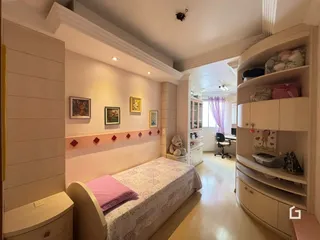 Quarto com cama e estantes em um ambiente claro.