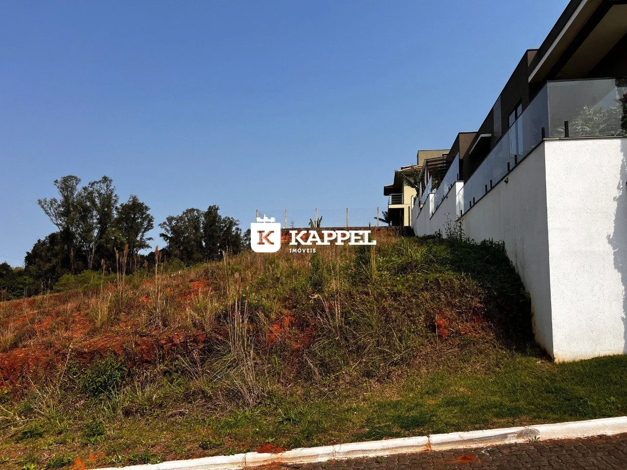 Vista externa de um prédio residencial com vegetação densa no primeiro plano.