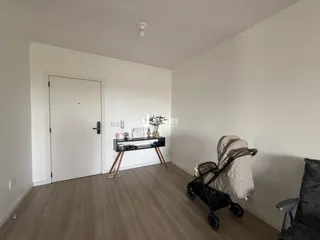 Ambiente interno de uma sala com piso de madeira clara e porta branca.