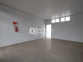Ambiente interno de uma sala vazia com piso de cerâmica.
