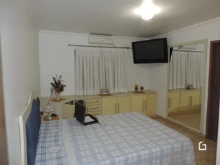 Quarto com cama e janela em ambiente interno.