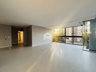 Ambiente interno amplo com piso claro e grande janela de vidro.