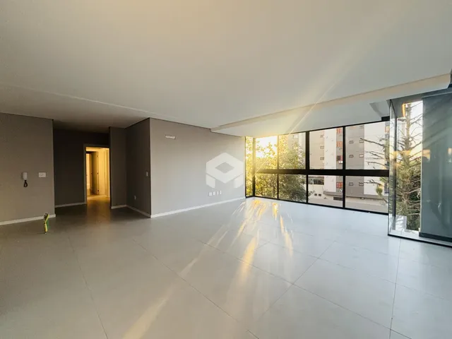 Ambiente interno amplo com piso claro e grande janela de vidro.