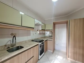 Cozinha com armários de madeira e bancada clara.