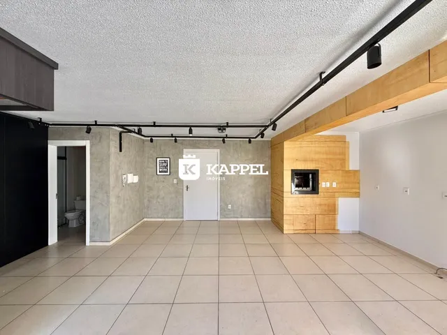Uma sala de estar ampla com piso de cerâmica e parede de madeira.