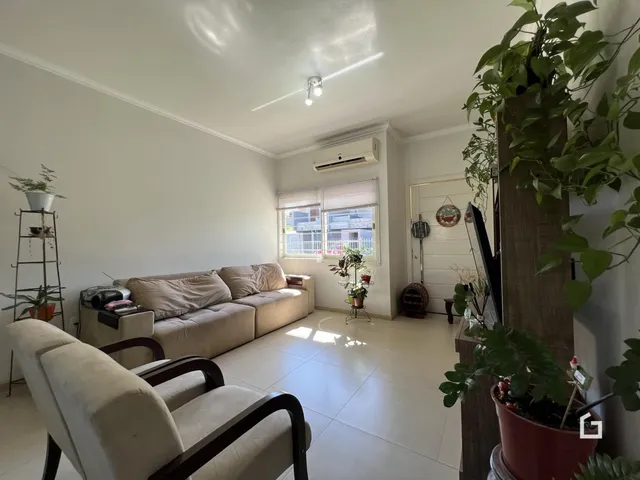 Sala de estar clara com sofá e janela em um imóvel no Brasil.